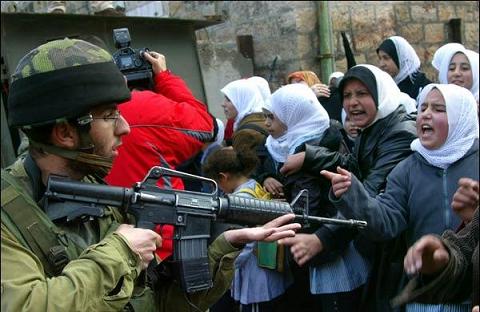 Un grupo de mujeres palestinas plantan cara a un soldado israelí