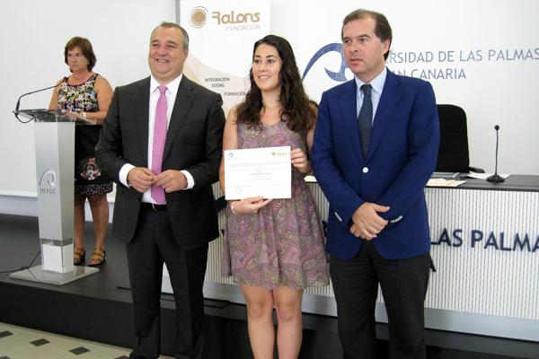Una de las estudiantes beneficiarias recoge el diploma acreditativo