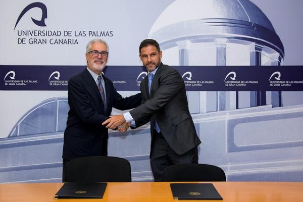 El Rector y el representante de CANARYFLY estrechan las manos tras la firma de los convenios