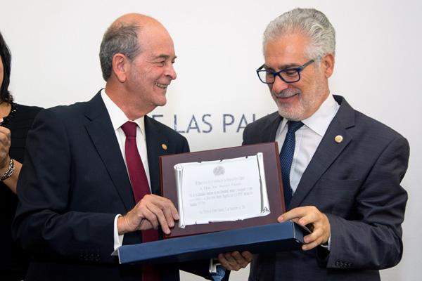 El Presidente del Consejo Social (i) entrega una placa conmemorativa al Rector José Regidor