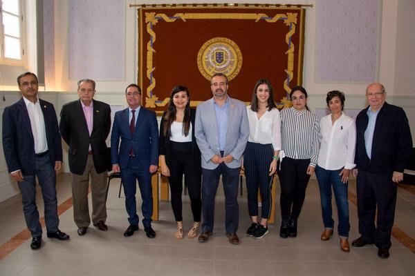 Foto de familia del Rector Robaina y el Vicerrector Peñate, junto con las alumnas becadas y los organizadores